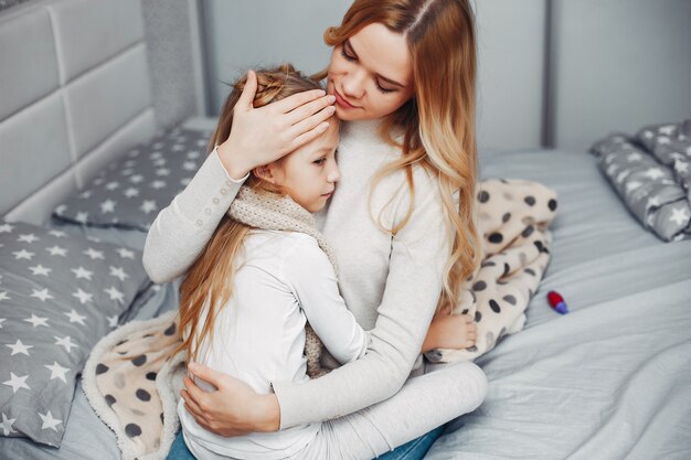 Madre con su hija illnes en un dormitorio