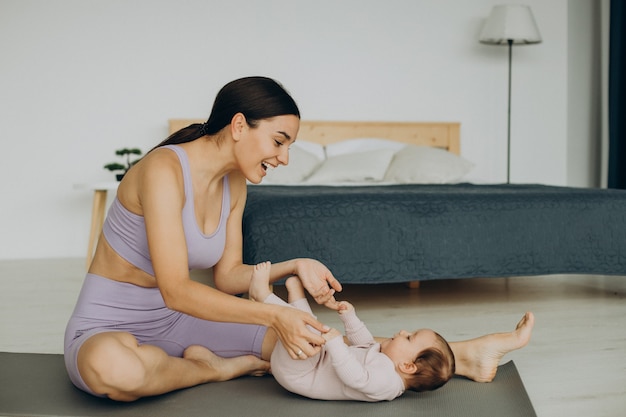 Madre con su hija practicar yoga en casa