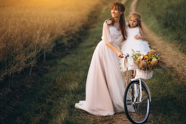 Madre con su hijo en hermosos vestidos con bicicleta