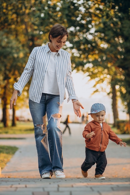 Madre con su hijo pequeño en el parque otoñal