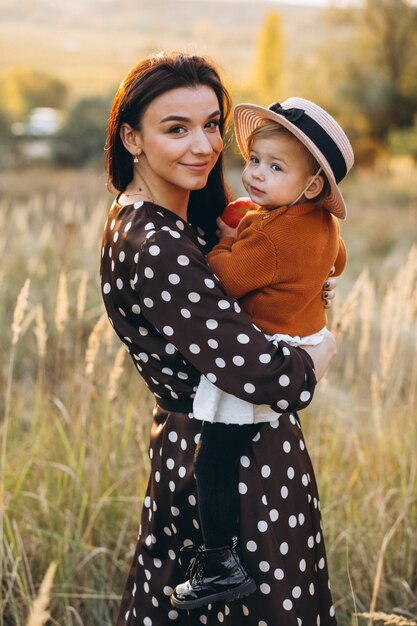 Madre con su niña en un campo de otoño