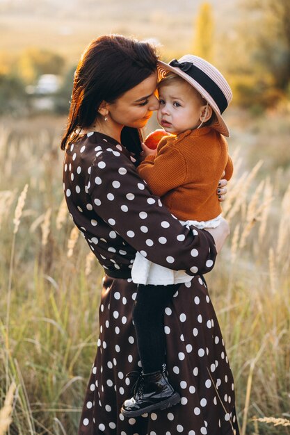 Madre con su niña en un campo de otoño