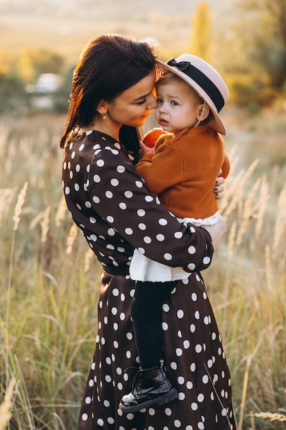 Madre con su niña en un campo de otoño