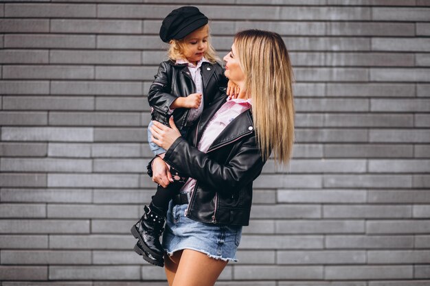 Madre con su pequeña hija fuera de la calle