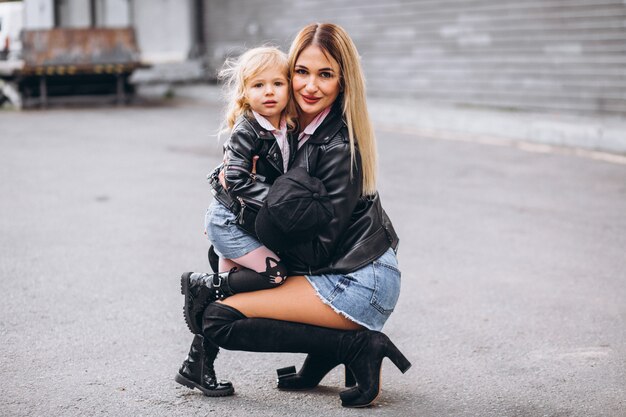 Madre con su pequeña hija fuera de la calle