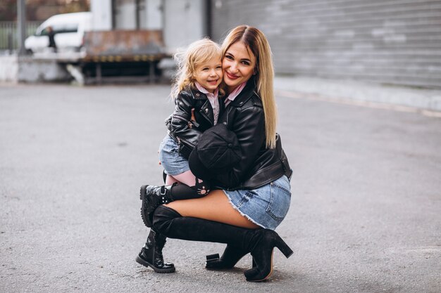 Madre con su pequeña hija fuera de la calle