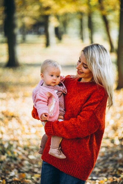 Madre con su pequeña hija en el parque en otoño