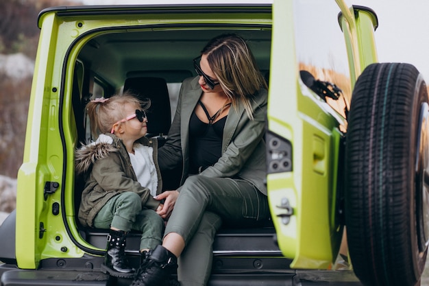 Madre con su pequeña hija sentada en la parte trasera del auto