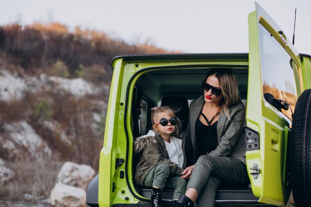 Madre con su pequeña hija sentada en la parte trasera del auto