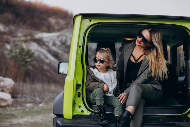 Madre con su pequeña hija sentada en la parte trasera del auto