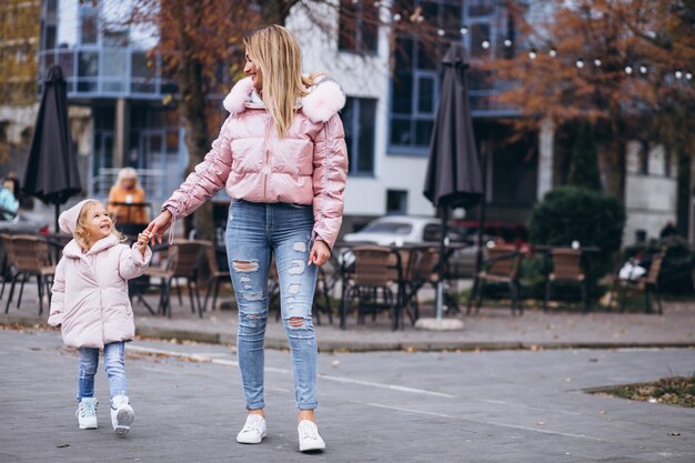 Madre con su pequeña hija vestida con ropa de abrigo fuera de la calle