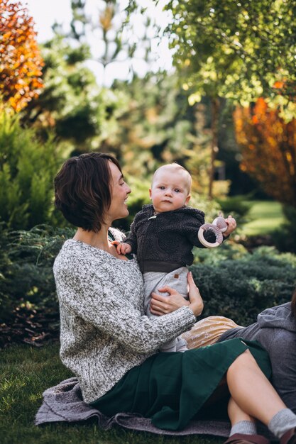 Madre con su pequeño hijo haciendo picnic en un patio trasero