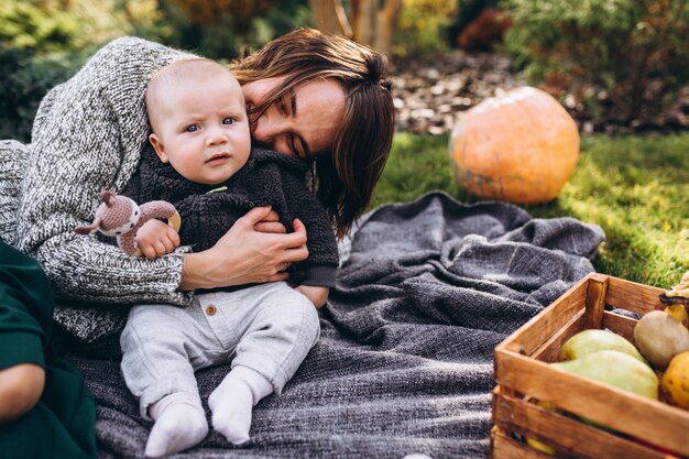 Madre con su pequeño hijo haciendo picnic en un patio trasero