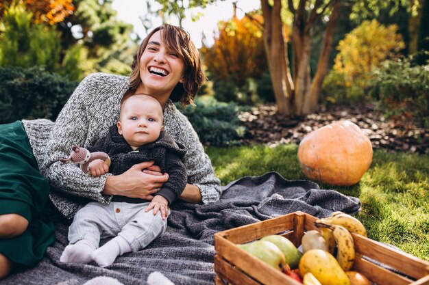 Madre con su pequeño hijo haciendo picnic en un patio trasero