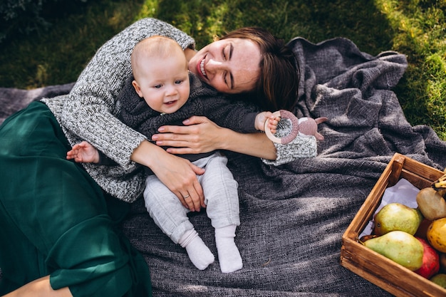 Madre con su pequeño hijo haciendo picnic en un patio trasero