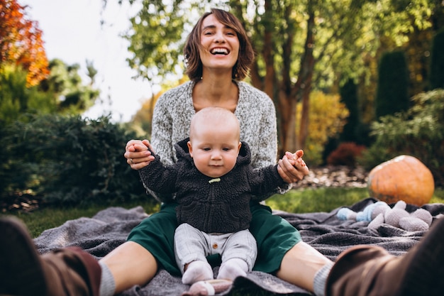 Madre con su pequeño hijo haciendo picnic en un patio trasero