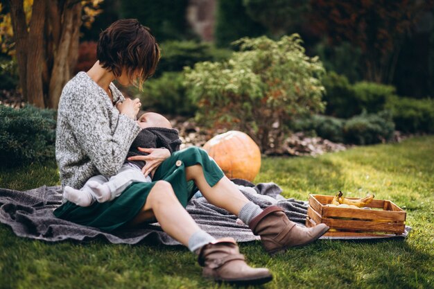 Madre con su pequeño hijo haciendo picnic en un patio trasero