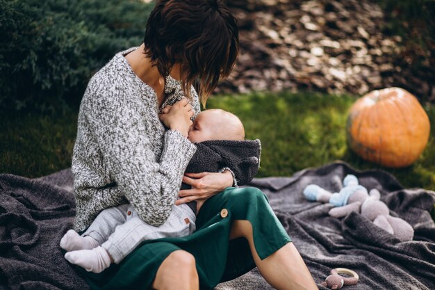 Madre con su pequeño hijo haciendo picnic en un patio trasero