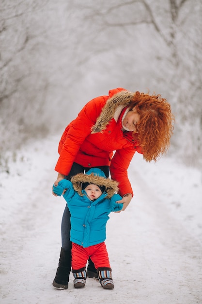 Madre con su pequeño hijo juntos en un parque de invierno