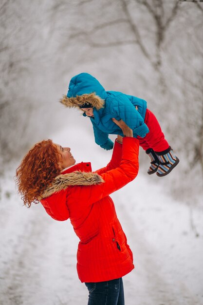 Madre con su pequeño hijo juntos en un parque de invierno