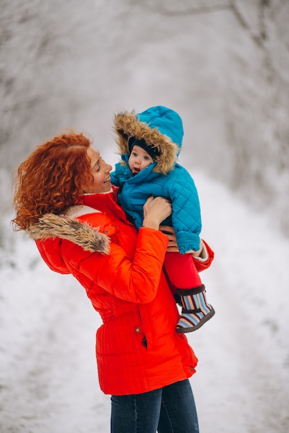 Madre con su pequeño hijo juntos en un parque de invierno