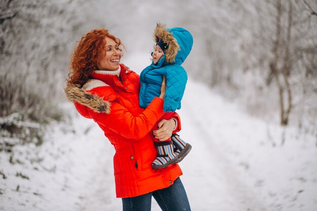 Madre con su pequeño hijo juntos en un parque de invierno