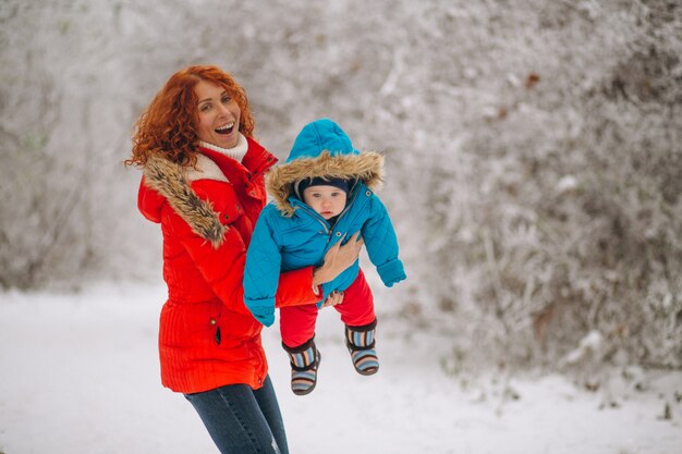 Madre con su pequeño hijo juntos en un parque de invierno