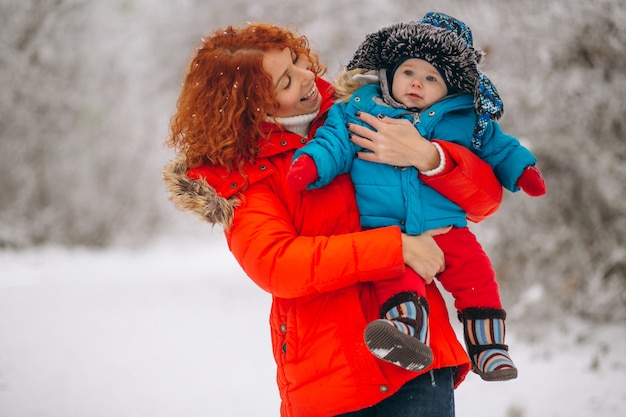 Madre con su pequeño hijo juntos en un parque de invierno