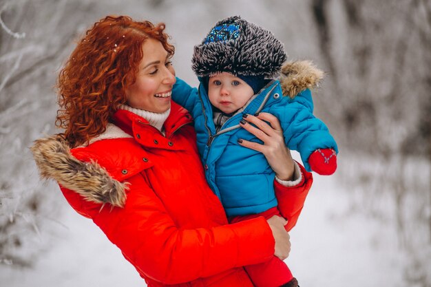 Madre con su pequeño hijo juntos en un parque de invierno