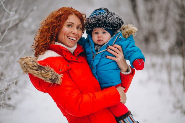 Madre con su pequeño hijo juntos en un parque de invierno