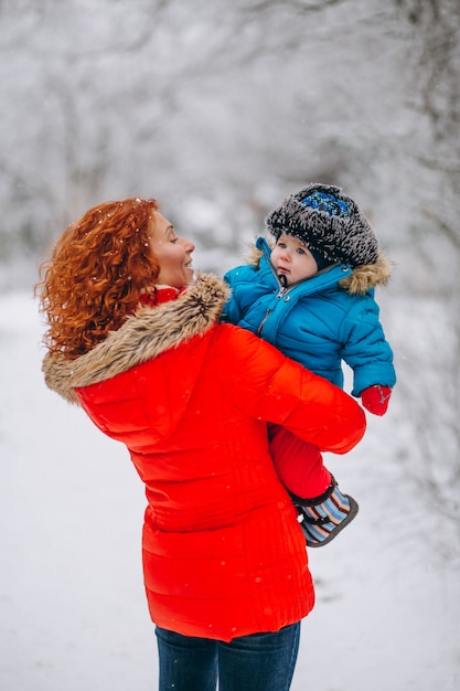 Madre con su pequeño hijo juntos en un parque de invierno