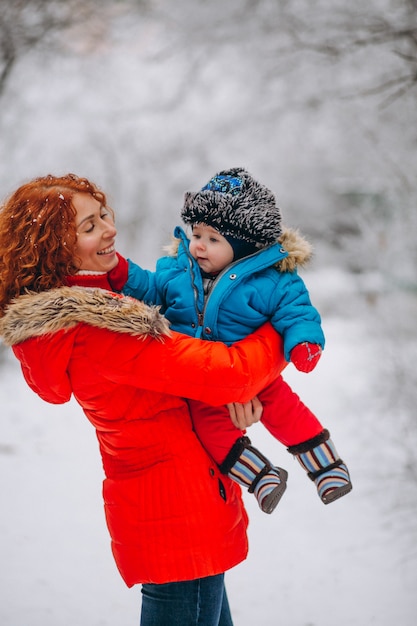 Madre con su pequeño hijo juntos en un parque de invierno