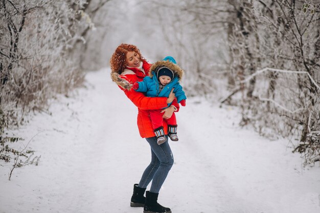 Madre con su pequeño hijo juntos en un parque de invierno