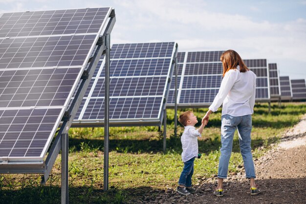 Madre con su pequeño hijo por paneles solares