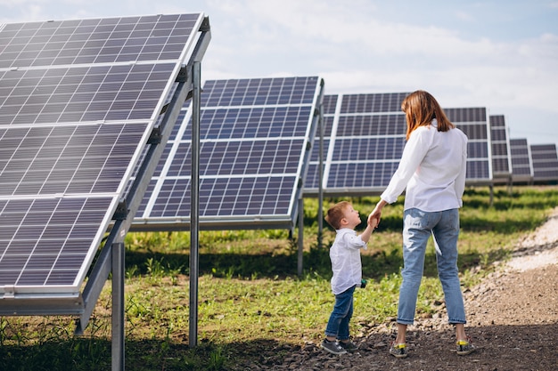 Madre con su pequeño hijo por paneles solares