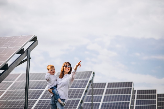 Madre con su pequeño hijo por paneles solares