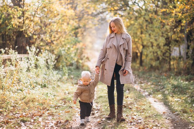 Madre con su pequeño hijo en el parque otoño