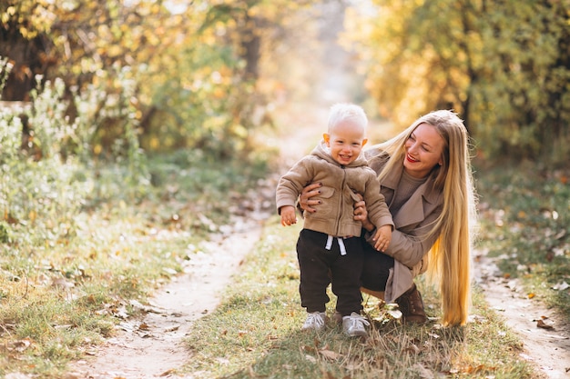 Madre con su pequeño hijo en el parque otoño