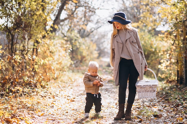 Madre con su pequeño hijo en el parque otoño