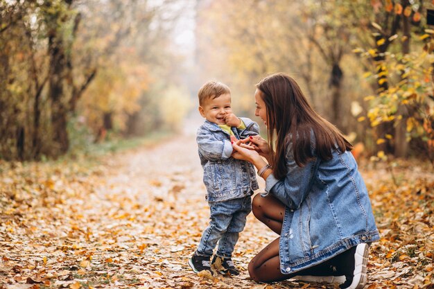 Madre con su pequeño hijo en el parque otoño