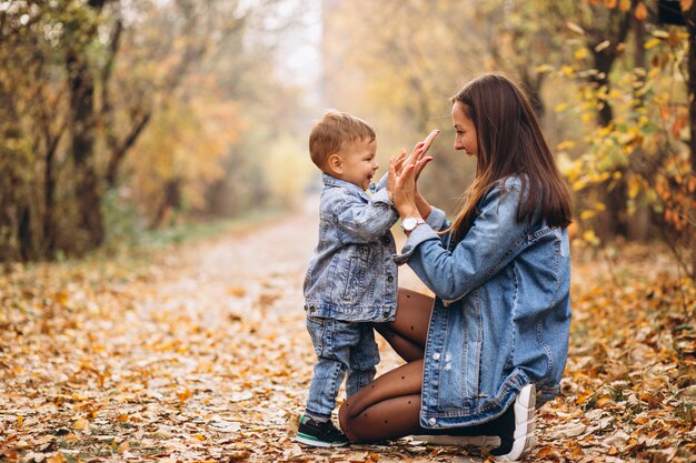 Madre con su pequeño hijo en el parque otoño