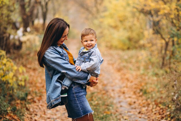 Madre con su pequeño hijo en el parque otoño