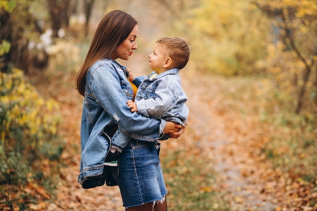 Madre con su pequeño hijo en el parque otoño