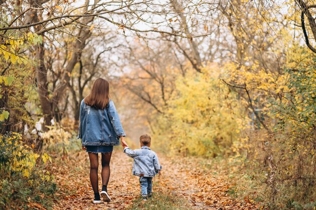 Madre con su pequeño hijo en el parque otoño