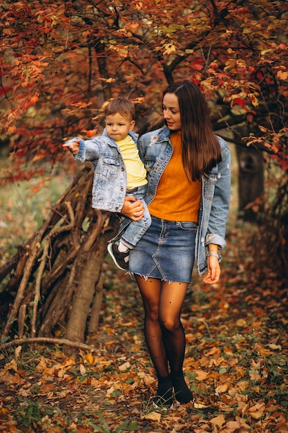 Madre con su pequeño hijo en el parque otoño