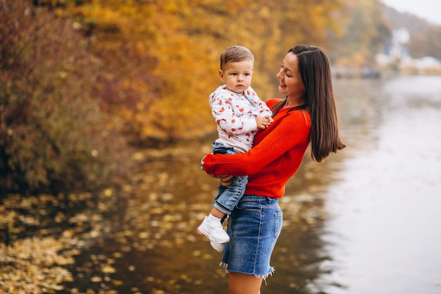 Madre con su pequeño hijo en el parque otoño