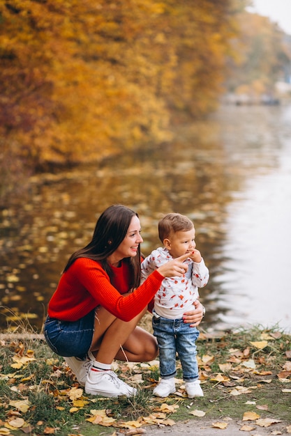 Madre con su pequeño hijo en el parque otoño