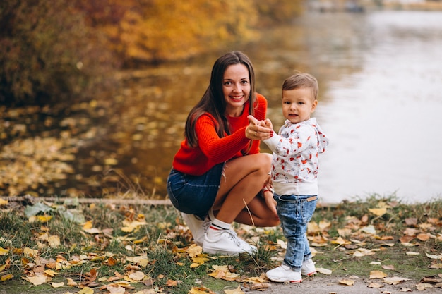 Madre con su pequeño hijo en el parque otoño