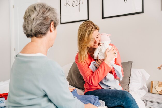 Madre sujetando bebé en la cama