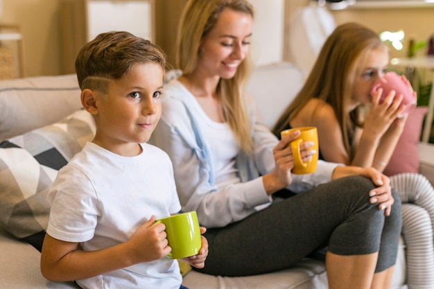 Madre y sus hijos bebiendo de tazas